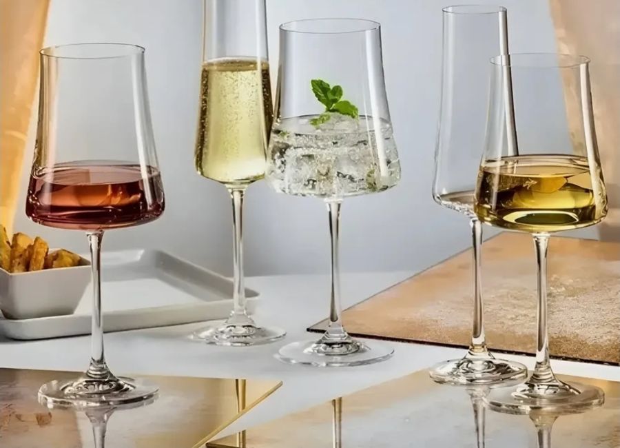 Taças de cristal transparentes com vinho tinto, branco e espumante